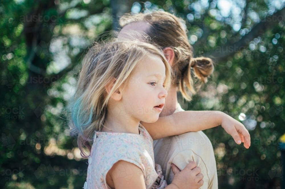 Little girl cuddling her father outside - Australian Stock Image