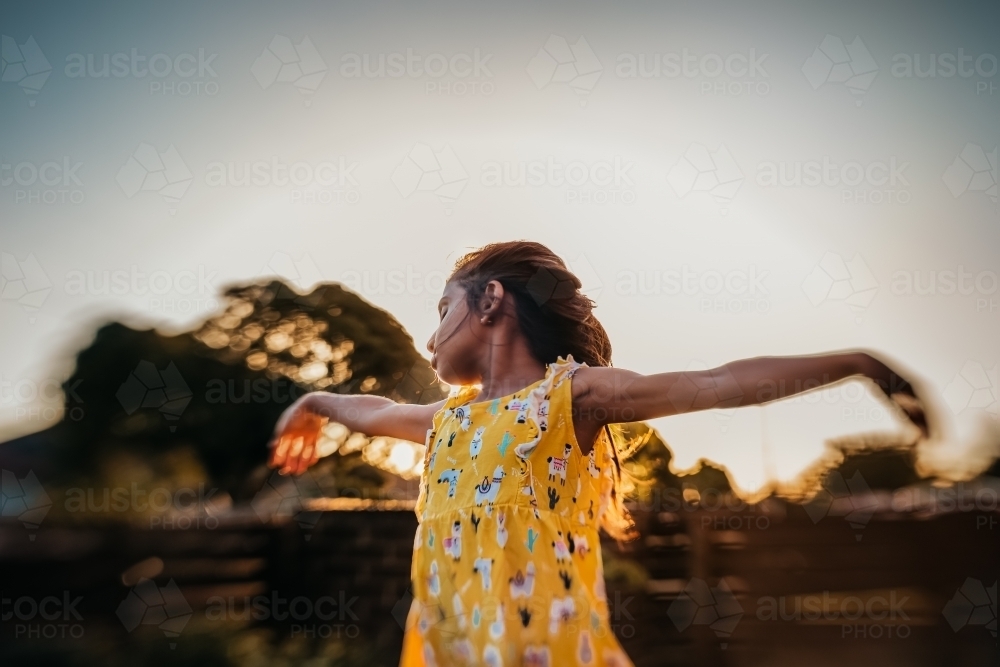 Little girl dancing during sunset - Australian Stock Image