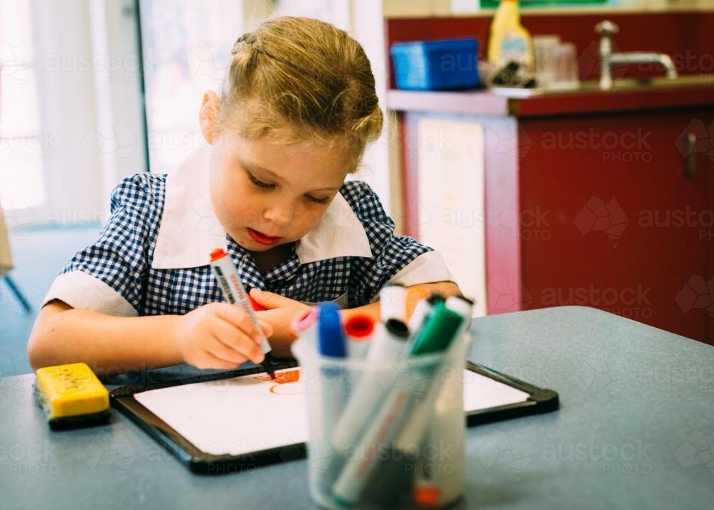 Little girl drawing in the classroom - Australian Stock Image