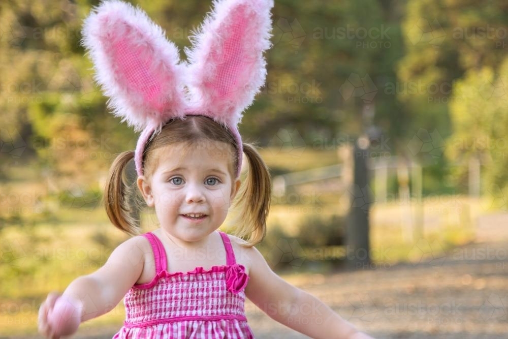 Little girl dressed up for Easter playing outside - Australian Stock Image