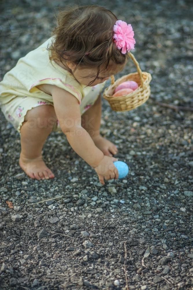 Little girl Easter egg hunting has found an egg - Australian Stock Image