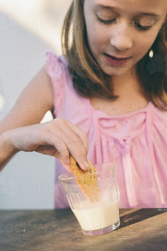 little girl enjoys her home made cookies and milk - Australian Stock Image