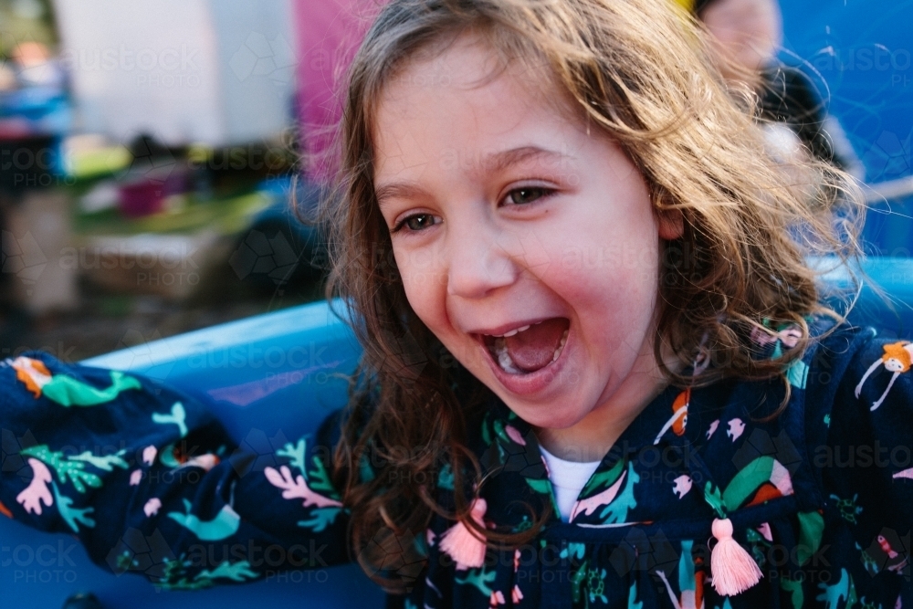 Little girl filled with joy on spinning ride - Australian Stock Image