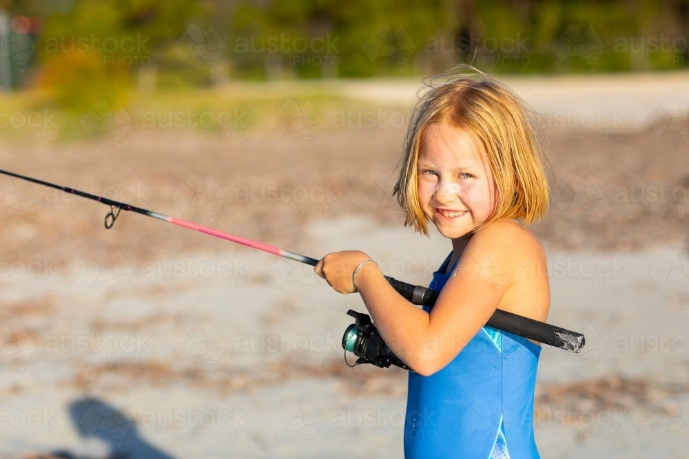 Image of Little girl fishing at the beach - Austockphoto