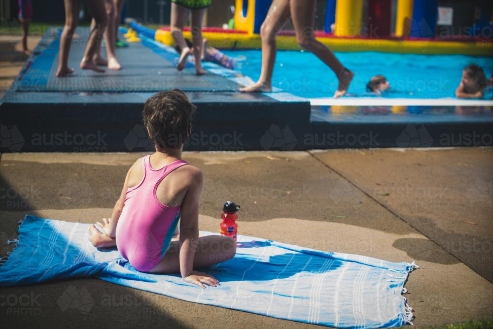 Little girl getting some sun at the poolside - Australian Stock Image