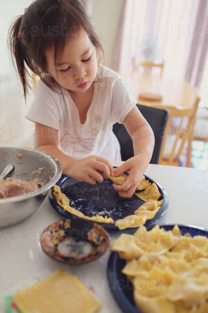 Little girl help making homemade wonton dumpling - Australian Stock Image