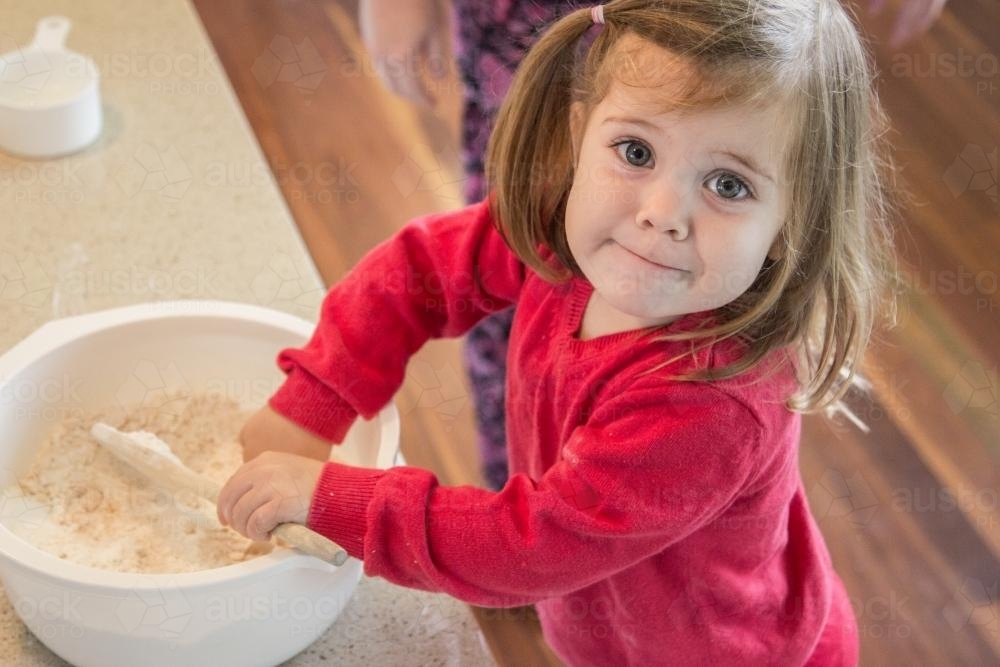 Little girl helping cook ANZAC biscuits - Australian Stock Image