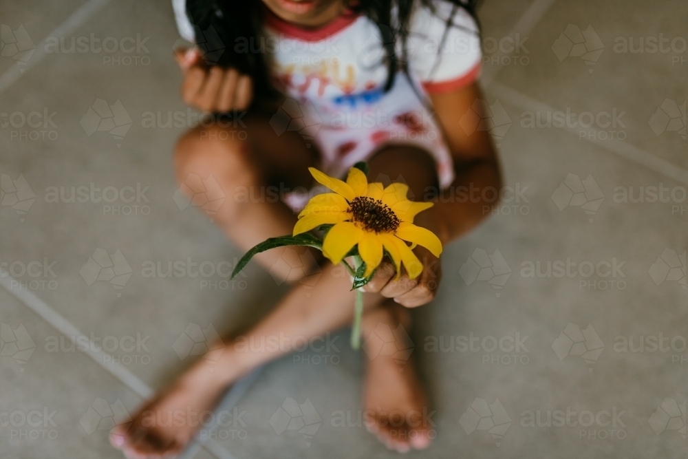 Little girl holding a sunflower - Australian Stock Image