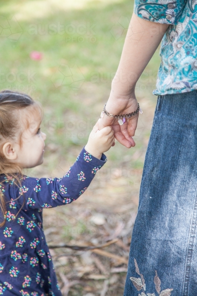Little girl holding big girls hand - Australian Stock Image