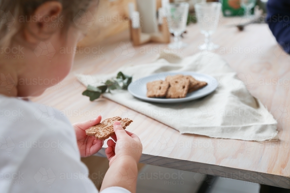 Little girl holding Christmas cookie - Australian Stock Image