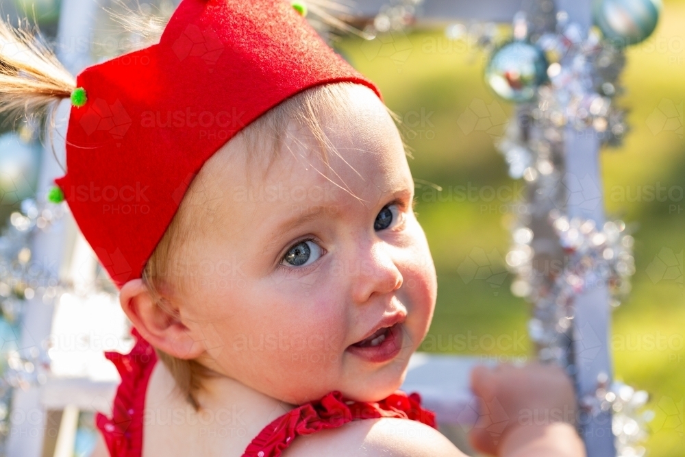 Little girl in red felt Christmas party hat - Australian Stock Image