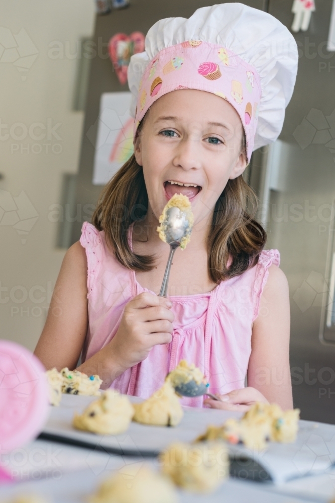 little girl licking the spoon - Australian Stock Image