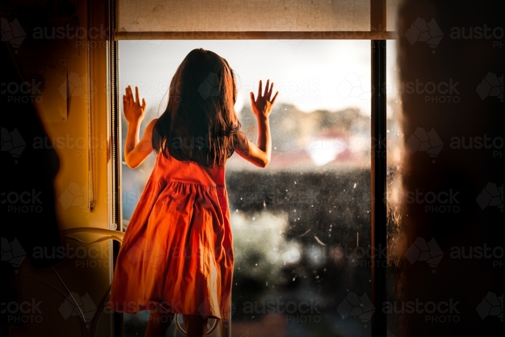 Little girl looking out the window - Australian Stock Image