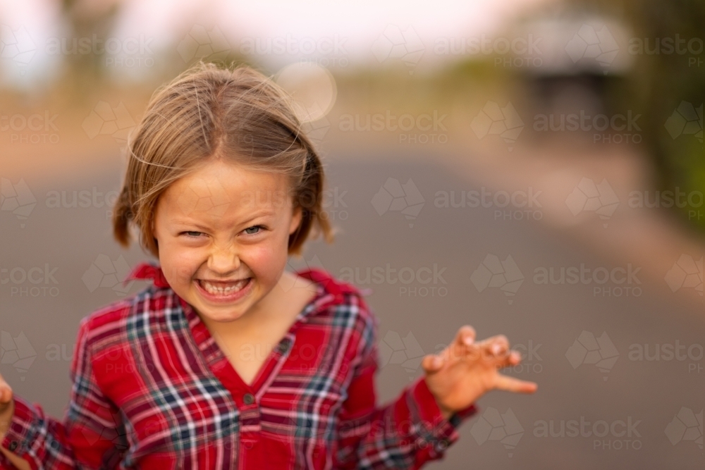 little girl outside making scary angry face - Australian Stock Image
