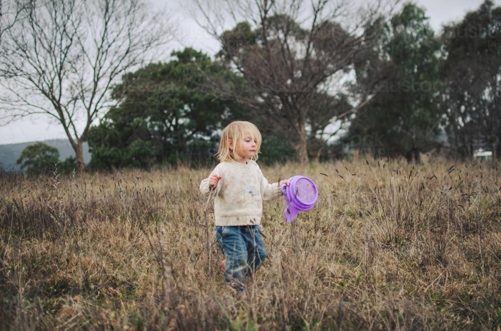 Little girl playing in a field - Australian Stock Image