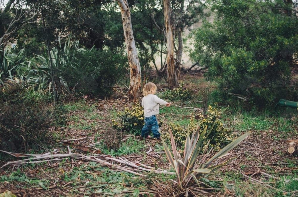 Little girl playing in bushland - Australian Stock Image
