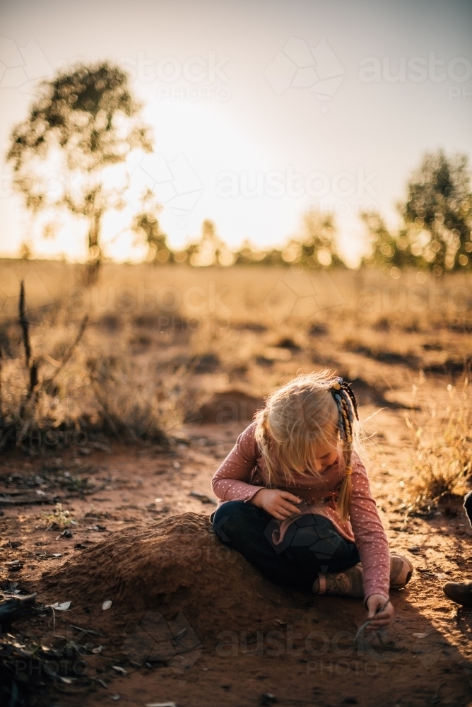 Little girl playing in the dirt on farm - Australian Stock Image