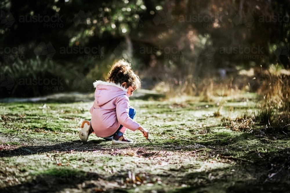 Little girl playing outdoors - Australian Stock Image