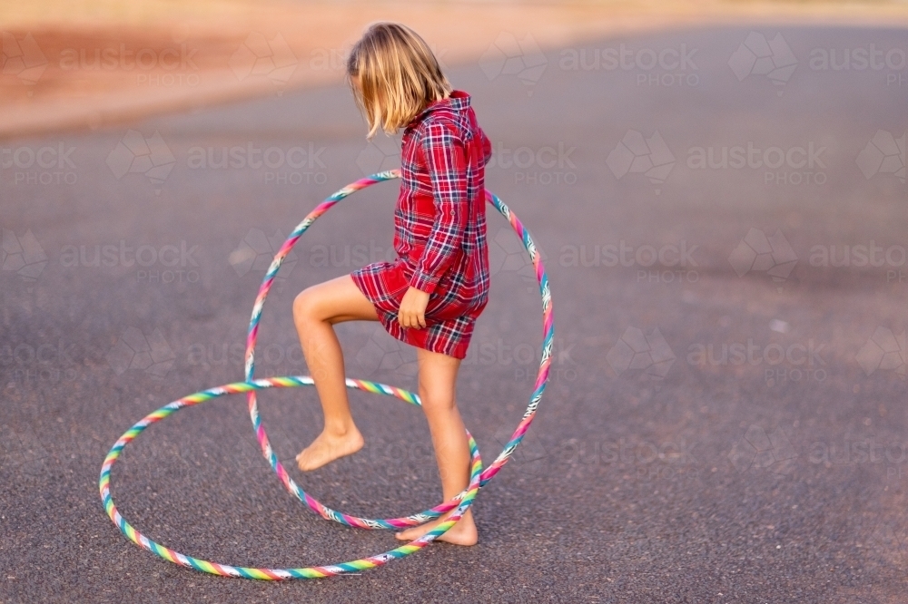 little girl playing with hoops outside - Australian Stock Image
