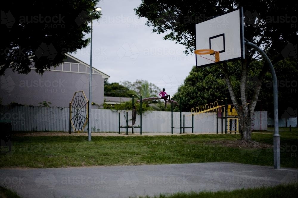 Little girl plays in suburban playground. - Australian Stock Image