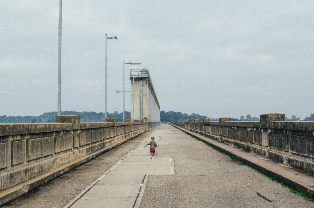 Little girl running at top of Hume Dam - Australian Stock Image