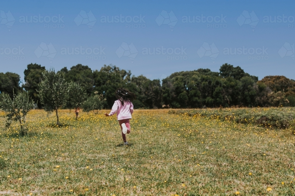 Little girl running in the field - Australian Stock Image