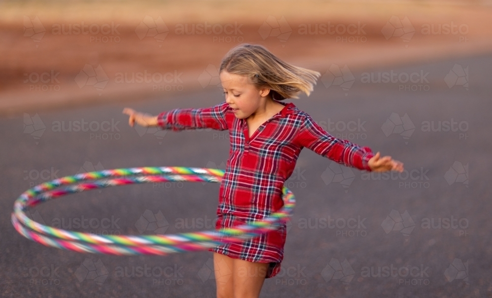little girl spinning two hula hoops around her waist - Australian Stock Image