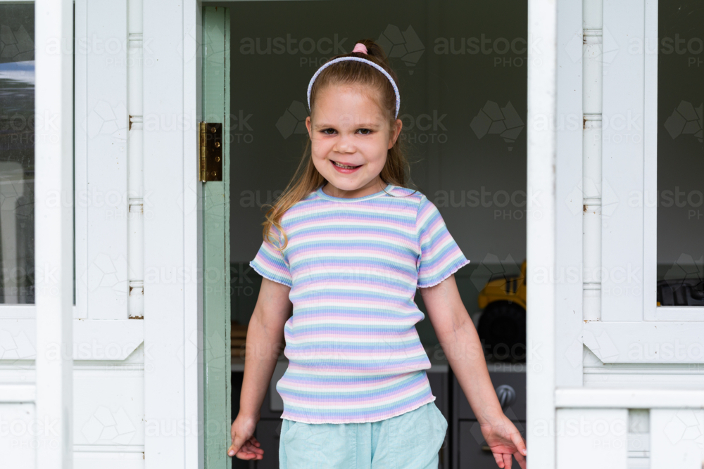 Little girl standing in play cubby house on farm with lymphatic malformation genetic condition - Australian Stock Image