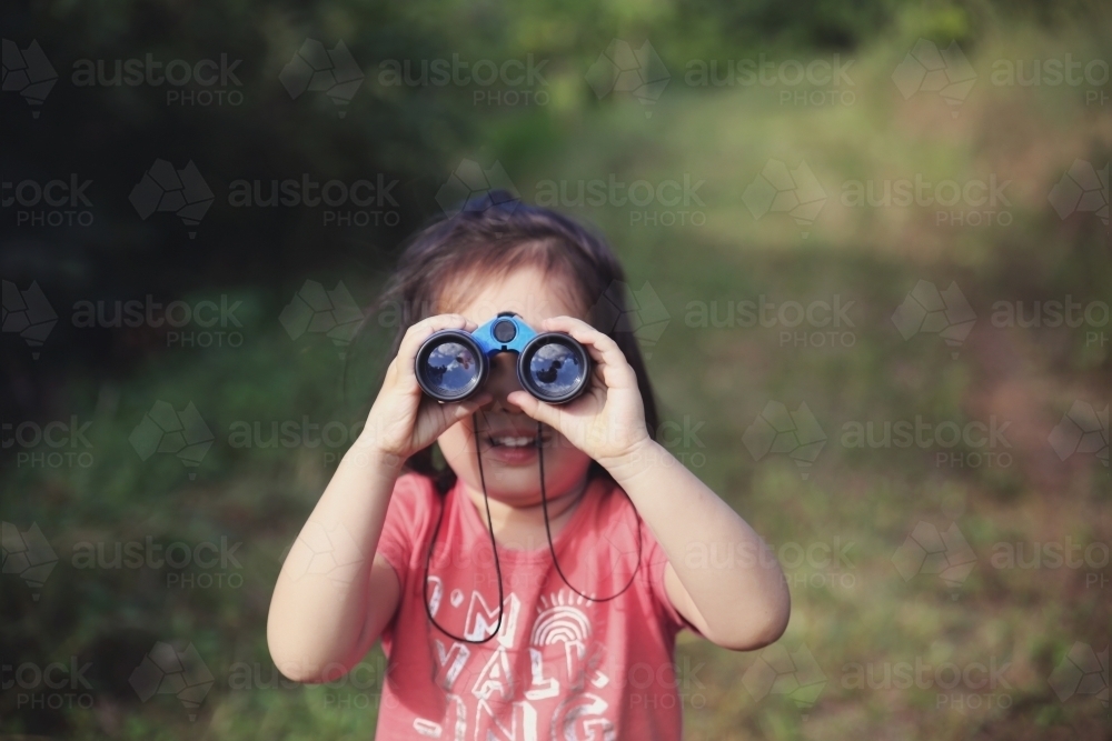 Little girl using binoculars - Australian Stock Image