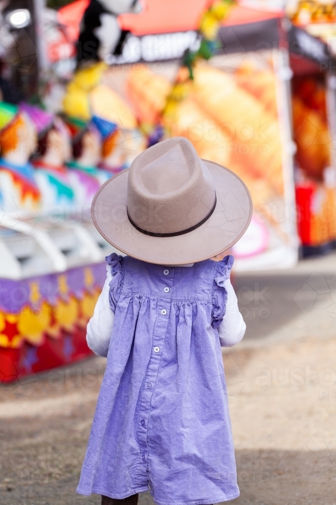 Little girl walking away at country show in sideshow alley - Australian Stock Image
