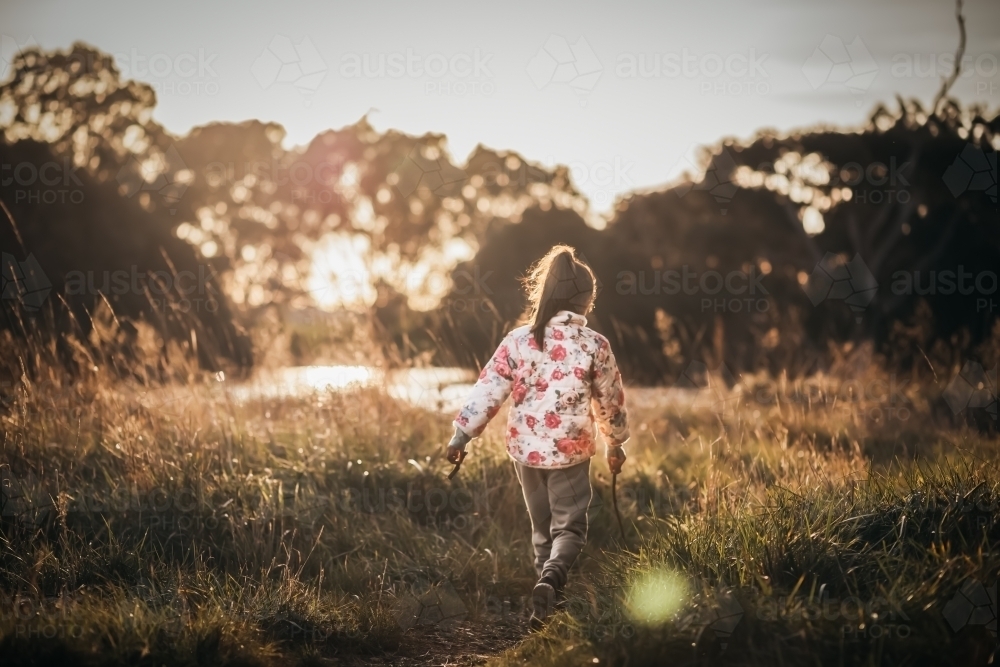Little girl walking near a lake - Australian Stock Image