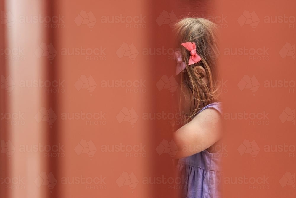 Little girl with pink and purple bows playing at the park - Australian Stock Image