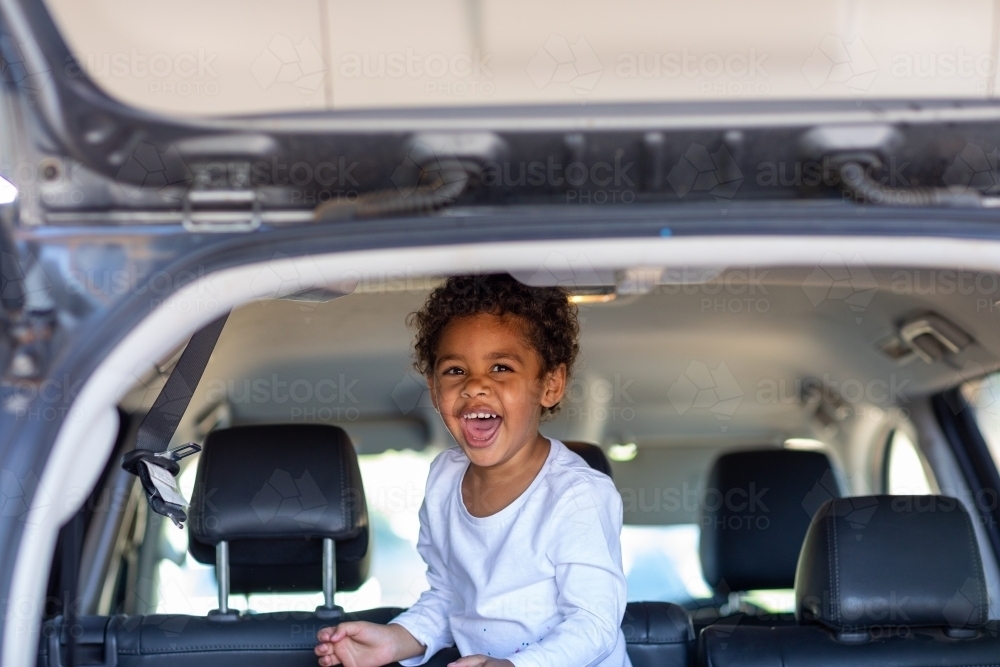 Little kid laughing in the back of a station wagon - Australian Stock Image