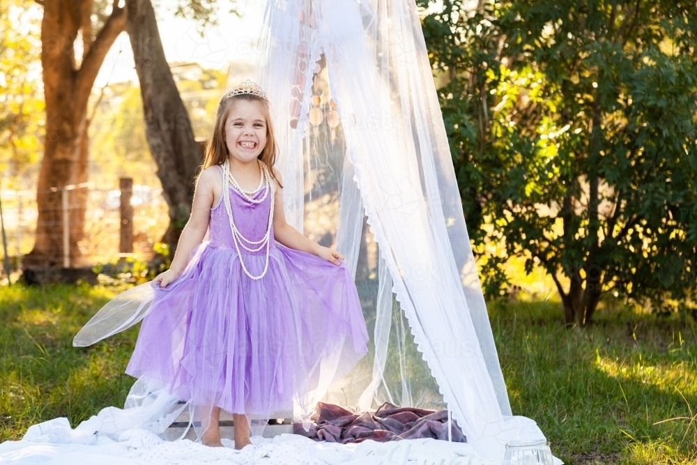 little kid playing imagine game dressed up as princess in purple dress - Australian Stock Image