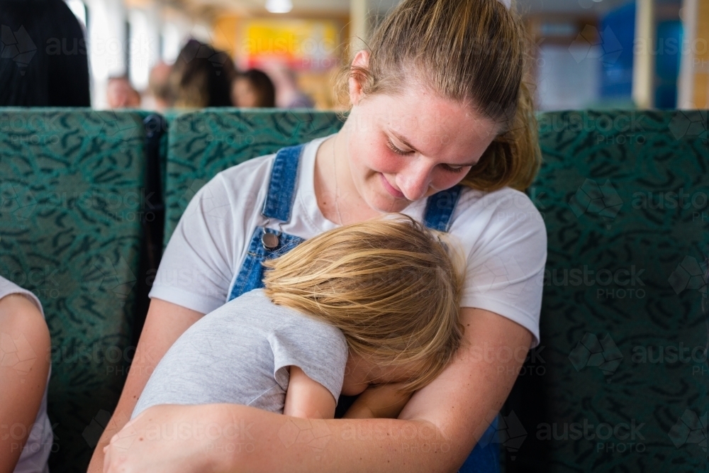 little kid sleeping on ferry - Australian Stock Image