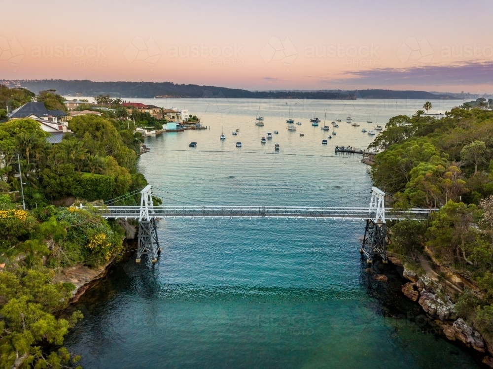 Little narrow cove in Sydney Harbour called Parsley Bay with a distinctive pedestrian bridge. - Australian Stock Image