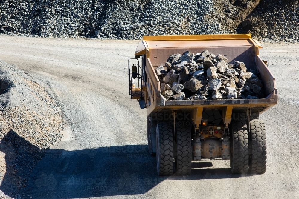 Loaded dump truck moving rock at a quarry mine - Australian Stock Image