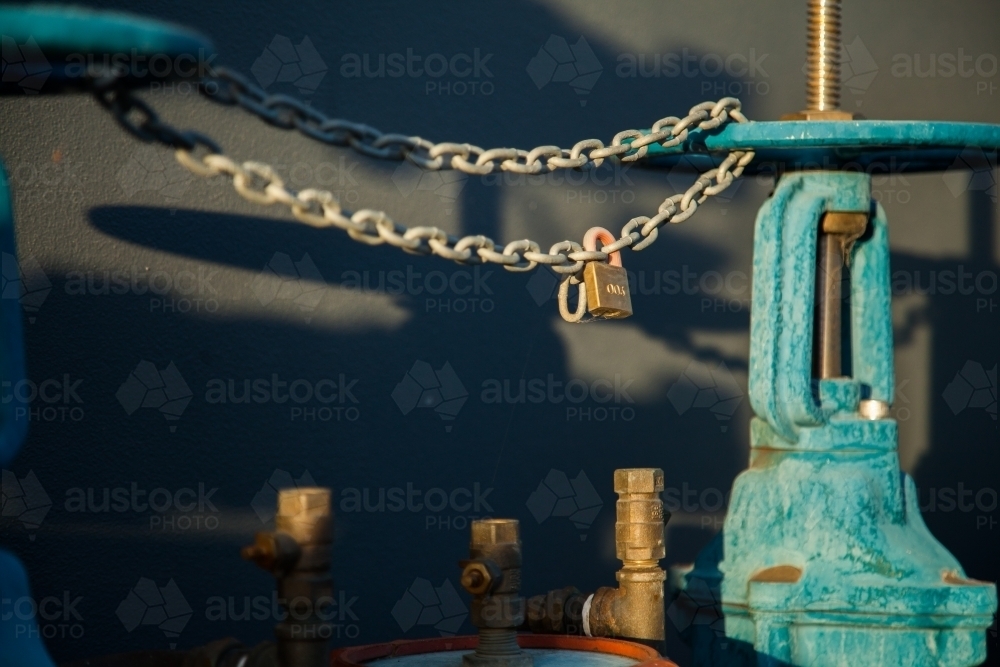 Lock on wheels and chains on a blue water hydrant - Australian Stock Image