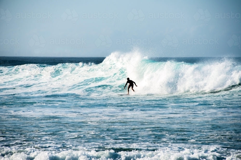 Lone surfer silhouette on wave - Australian Stock Image