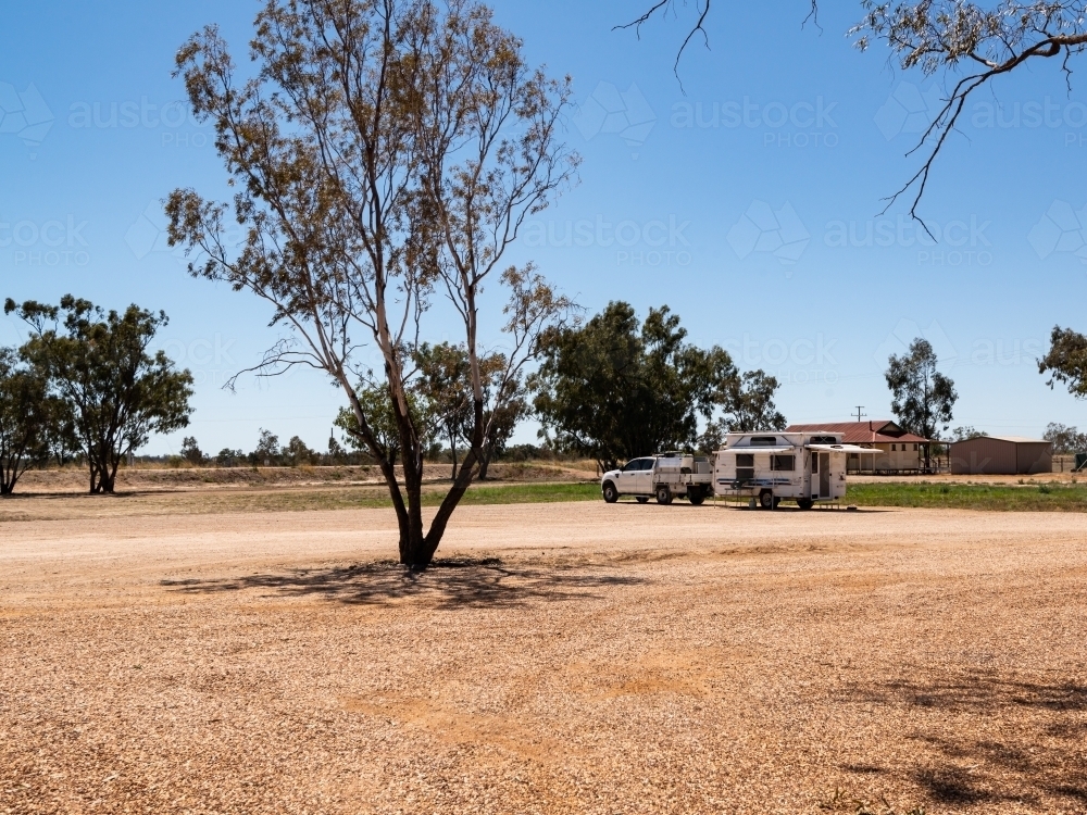 lone vehicle and caravan in a bare country camping area. - Australian Stock Image