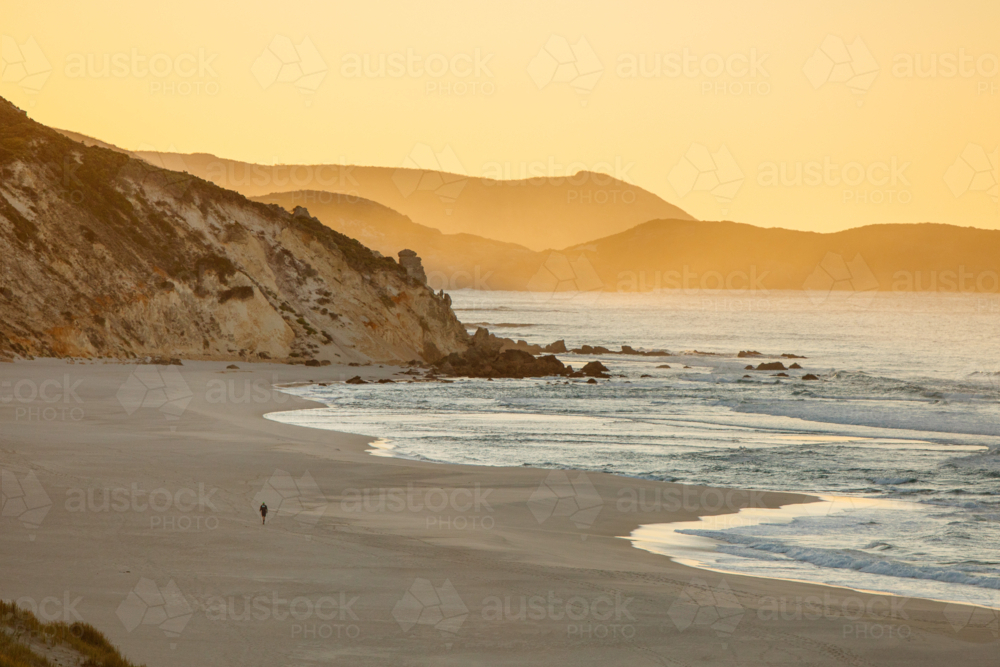 Lone walker on rugged coastline - Australian Stock Image