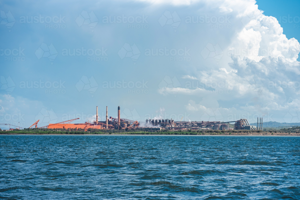 Long distance view of an industrial port with cargo ships and conveyors - Australian Stock Image