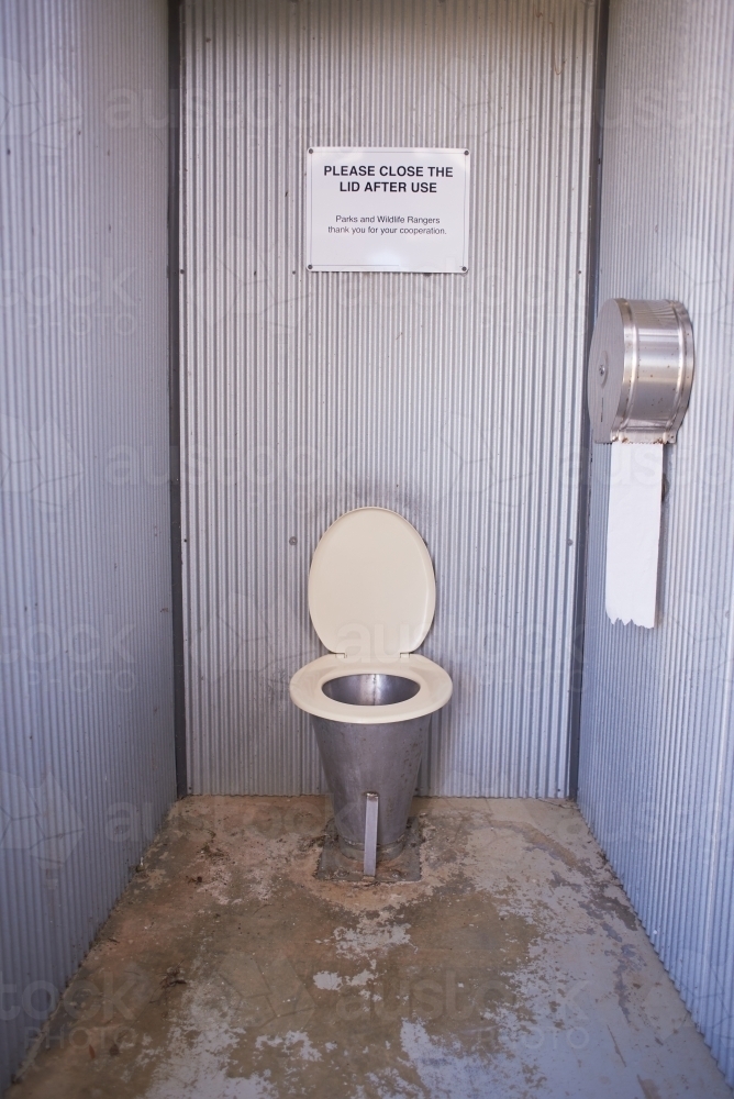 Long drop public toilet in a remote picnic area, with toilet paper. - Australian Stock Image