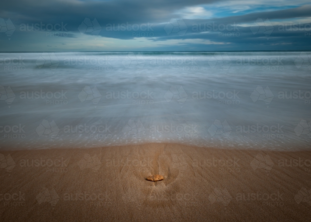 Long Exposure Beach, A Rock on a Golden Sandy Beach on an Overcast Day - Australian Stock Image