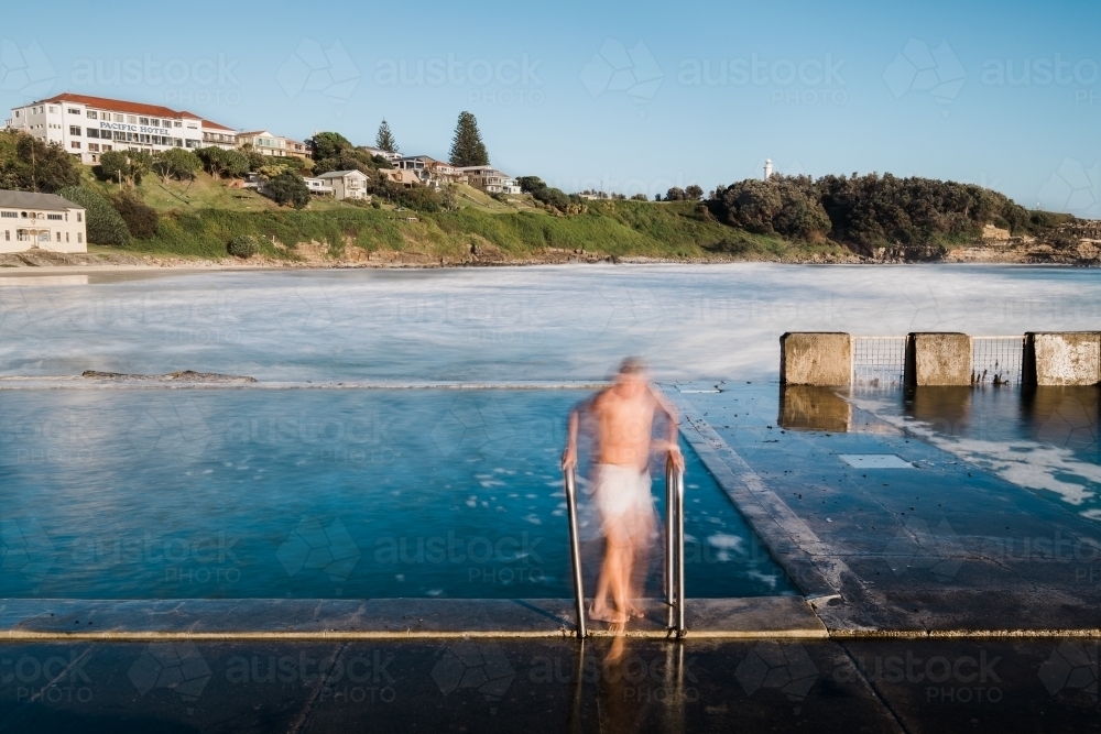 Long exposure of a swimmer leaving the ocean pool - Australian Stock Image