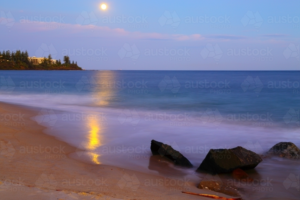 Long exposure of the supermoon full moon rising over Kings Beach, Caloundra - Australian Stock Image