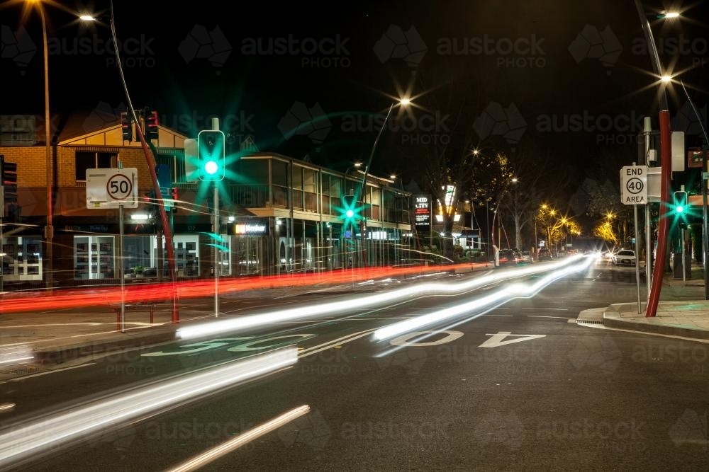 Long exposure streetscape of traffic lights in small town at night - Australian Stock Image