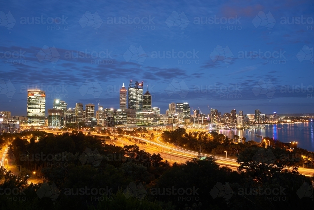 Long exposure trails of light underneath the Perth City skyline at the last light of the day. - Australian Stock Image