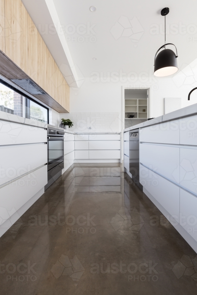 Long galley style kitchen with polished concrete floor - Australian Stock Image
