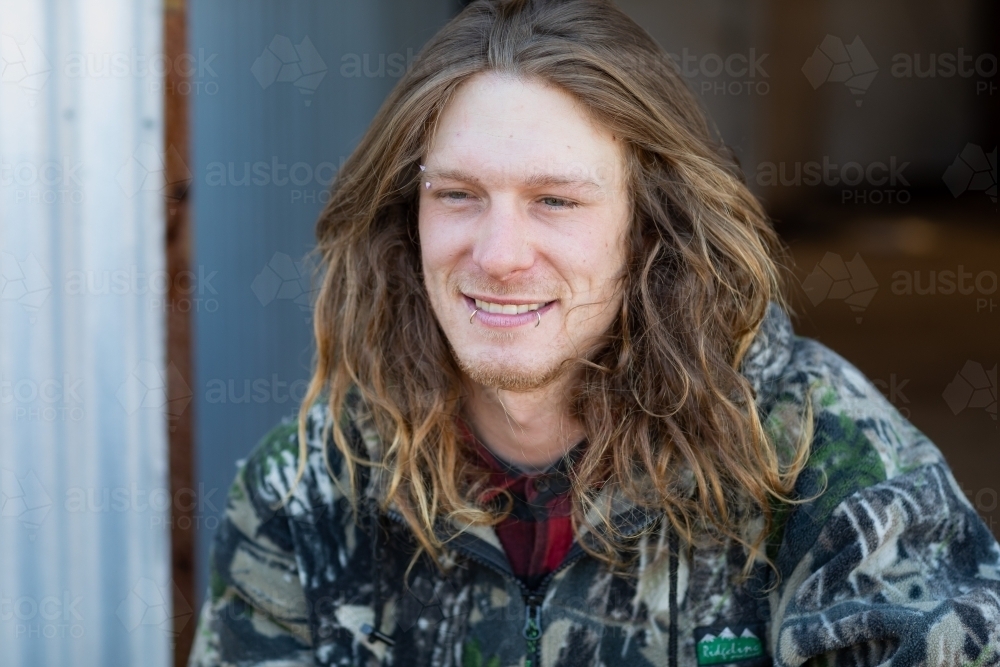long haired bloke wearing camouflage jacket - Australian Stock Image